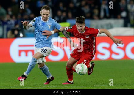 LazioÕs der italienische Mittelfeldspieler Manuel Lazzari fordert gemeinsam mit Alkmaar Zaanstreeks ungarischem Verteidiger Milos Kerkez während der Runde des ersten Spiels der UEFA Conference Liga 16 zwischen SS Lazio und Alkmaar Zaanstreek den Ball an. AZ Alkmaar gewann 2-1 Stockfoto