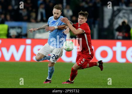 LazioÕs der italienische Mittelfeldspieler Manuel Lazzari fordert gemeinsam mit Alkmaar Zaanstreeks ungarischem Verteidiger Milos Kerkez während der Runde des ersten Spiels der UEFA Conference Liga 16 zwischen SS Lazio und Alkmaar Zaanstreek den Ball an. AZ Alkmaar gewann 2-1 Stockfoto