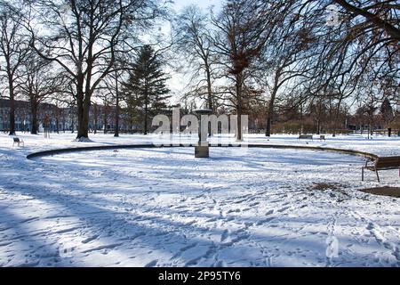Karlsruhe, Deutschland - 12. Februar 2021: Wasserbrunnen im Schnee in den Gärten des Karlsruhe-Schlosses an einem kalten Wintertag in Deutschland. Stockfoto
