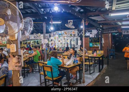 Ein traditionelles Straßenrestaurant mit einer schmalen Passage für Motorroller in Thailand, Asien Stockfoto