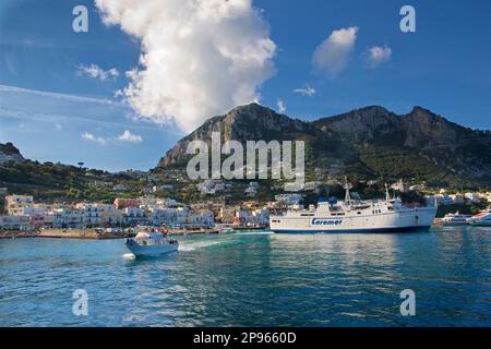 Wir nähern uns dem Hafen von Capri mit dem Boot. Capri ist eine Insel im Tyrrhenischen Meer vor der Halbinsel Sorrent, auf der Südseite des Golfs von Neapel im Campaniaregion von Italien Capri, berühmt für seine zerklüftete Landschaft, kulturelle Geschichte, gehobene Hotels und Einkaufsmöglichkeiten Stockfoto