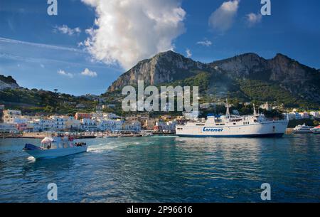 Wir nähern uns dem Hafen von Capri mit dem Boot. Capri ist eine Insel im Tyrrhenischen Meer vor der Halbinsel Sorrent, auf der Südseite des Golfs von Neapel im Campaniaregion von Italien Capri, berühmt für seine zerklüftete Landschaft, kulturelle Geschichte, gehobene Hotels und Einkaufsmöglichkeiten Stockfoto