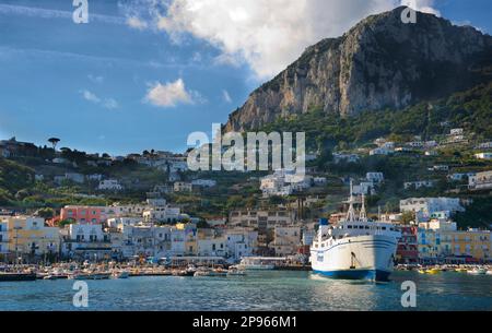 Wir nähern uns dem Hafen von Capri mit dem Boot. Capri ist eine Insel im Tyrrhenischen Meer vor der Halbinsel Sorrent, auf der Südseite des Golfs von Neapel im Campaniaregion von Italien Capri, berühmt für seine zerklüftete Landschaft, kulturelle Geschichte, gehobene Hotels und Einkaufsmöglichkeiten Stockfoto