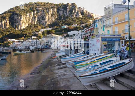 Capri Harbourt mit kleinen Ruderbooten, die am Ufer angehalten haben. Capri ist eine Insel im Tyrrhenischen Meer vor der Halbinsel Sorrent, auf der Südseite des Golfs von Neapel im Campaniaregion von Italien Capri, berühmt für seine zerklüftete Landschaft, kulturelle Geschichte, gehobene Hotels und Einkaufsmöglichkeiten Stockfoto