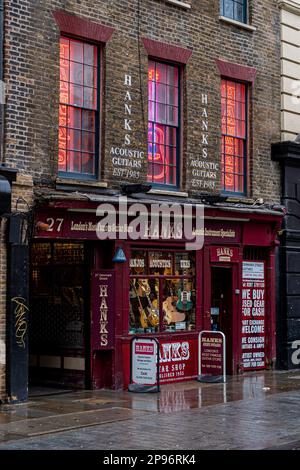 Hanks Guitar Store in Londons berühmter Demark Street im Viertel Soho, einst bekannt als Tin Pan Alley. Gegründet 1985. Hanks Guitar Shop London. Stockfoto