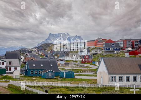 Viele farbige Häuser vor einer schneebedeckten Bergkulisse in Nuuk, Grönland am 20. Juli 2022 Stockfoto