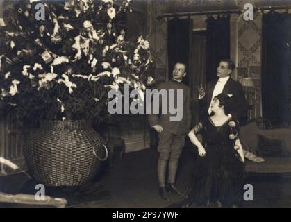 1917 , Roma , Teatro Argentina : der italienische Theaterautor und Dramatiker LUIGI CHIARELLI ( Trani 1880 - Roma 1947 ) . Auf diesem Foto mit den Schauspielern Giulietta Deriso und Annibale Ninchi im 2. Akt der Komödie LE LACRIME Le STELLE von Chiarelli , Compagnia Talli - LETTERATO - SCRITTORE - LETTERATURA - Literatur - Drammaturgo - TEATRO - THEATRE - THEATER - Commediografo - De Riso - ritratto - 1. Weltkrieg - großer Krieg - Grande Guerra - Prima Guerra Mondiale - Militäruniform - Uniforme divisa militare - Albero di Natale - Christmans - Archivio GBB Stockfoto