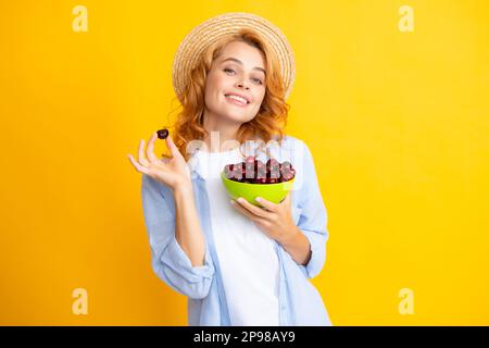 Porträt einer Beauty-Redhed-Frau mit Kirschen auf gelbem isoliertem Hintergrund Stockfoto