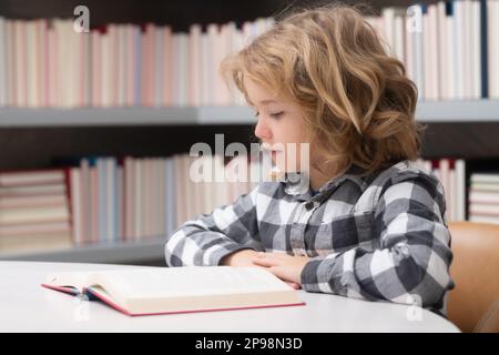 Bildung und Schulkonzept. Ein Kind liest Buch in einem Buchladen oder einer Bibliothek Stockfoto