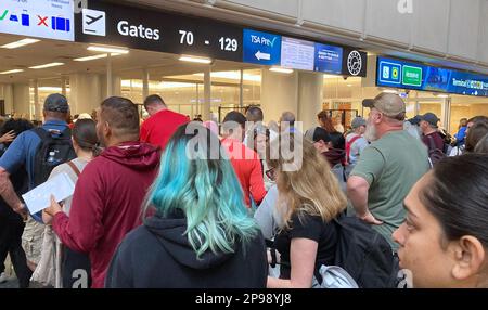 Orlando, Florida, USA. 10. März 2023. Reisende warten während der geschäftigen Frühlingsferien in Orlando in einer TSA-Schlange am internationalen Flughafen von Orlando. Für die Frühjahrsferien von dieser Woche bis zum 18. April werden voraussichtlich 7,3 Millionen Passagiere den Flughafen von Orlando passieren. (Credit Image: © Paul Hennessy/SOPA Images via ZUMA Press Wire) NUR REDAKTIONELLE VERWENDUNG! Nicht für den kommerziellen GEBRAUCH! Stockfoto