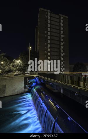 Nachtbild eines Fußwegs über einen kleinen Wasserfall, der in einem Staudamm des Flusses manzanares in Madrid entstanden ist Stockfoto