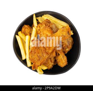 Hähnchenschenkel isoliert, gebratener panierter Drumstick, frittierte Hühnchen Drumsticks mit Pommes Frites in Black Bowl auf weißem Hintergrund Draufsicht Stockfoto