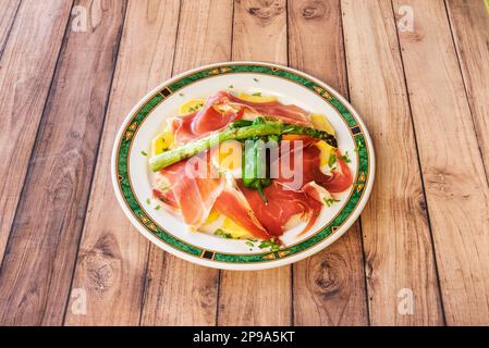 Eine wunderbare und typisch spanische Tapa mit Rührei mit Schinken, Paprika, Bratkartoffeln und gegrilltem Wildspargel Stockfoto