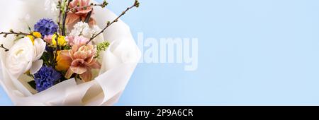 Ein strahlender Frühlingsstrauß aus Narzissen, Hyazinthen, Rosen, Ranunculus, Tulpen, Flieder und ein Zweig prunus. Hallo Frühling. Banner Stockfoto