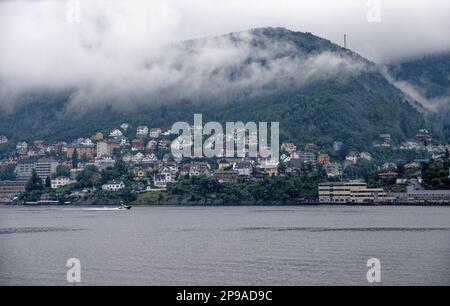 Blick auf die Küste über den Hafen von Vagen bis zum Ufer von Torget und Mount Ulriken über der historischen Stadt Bergen, Norwegen und Skandinavien. 19. vom Juli 2012 Stockfoto