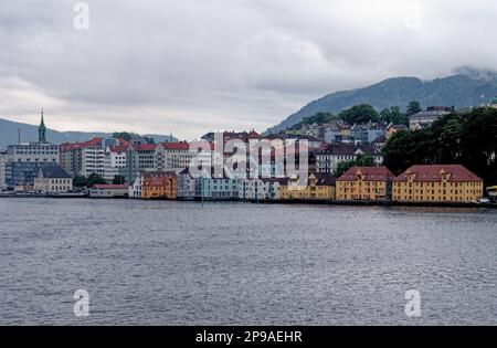 Blick auf die Küste über den Hafen von Vagen bis zum Ufer von Torget und Mount Ulriken über der historischen Stadt Bergen, Norwegen und Skandinavien. 19. vom Juli 2012 Stockfoto