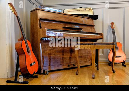 Gitarre, Klavierhocker und ein Klavier in einem Oldtimer-Haus in Alesund, Norwegen. 19. vom Juli 2012 Stockfoto