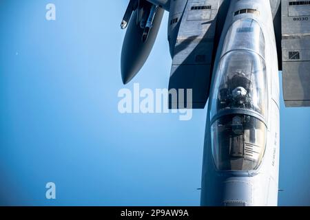 Ein F-15 Strike Eagle, der dem 96. Test Wing zugewiesen wurde, Eglin Air Force Base, Florida, nähert sich einem KC-135 Stratotanker, der dem 6. Air Tanken Wing, MacDill Air Force Base, Florida, zugeteilt wurde, um über dem Golf von Mexiko zu tanken, am 8. März 2023. Durch die Luftbetankung durch Tankflugzeuge können der F-15 und andere Flugzeuge länger in der Luft bleiben und die Landung in umkämpften Gebieten vermeiden. (USA Air Force Foto von Senior Airman Lauren Cobin) Stockfoto