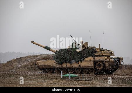 USA Soldaten der NATO EFP Battle Group Polen, die dem 2. Bewaffneten Brigaden-Kampfteam, 1. Kavalleriedivision, zugewiesen sind und die 4. Infanteriedivision unterstützen, führen am 7. März 2023 Feuerübungen mit einem M1A2 Abrams-Panzer in Bemowo Piskie, Polen, durch. Die 4. Inf. Die Aufgabe der Div in Europa besteht darin, sich an multinationalen Schulungen und Übungen auf dem ganzen Kontinent zu beteiligen und gemeinsam mit NATO-Verbündeten und regionalen Sicherheitspartnern Kampfkräfte für das V Corps, das in Europa stationierte US-Korps, bereitzustellen. (USA Armeenationalgarde (Foto von Sergeant Lianne M. Hirano) Stockfoto