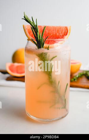 Honig Rosemary Grapefruit Soda garniert mit Red Grapefruit: Alkoholfreie Soda serviert in Dosen Gläsern mit Eiswürfeln Stockfoto