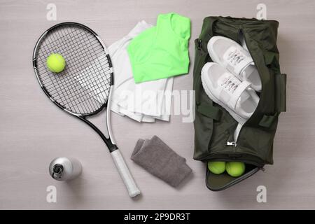 Sporttasche und Tennisausrüstung auf Holzhintergrund, flach liegend Stockfoto