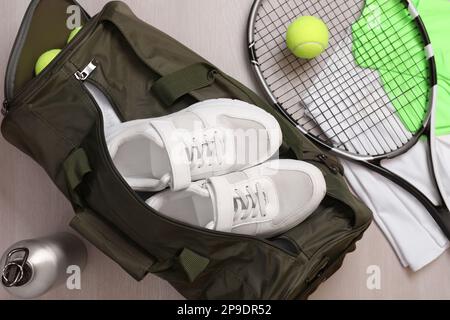 Sporttasche und Tennisausrüstung auf Holzhintergrund, flach liegend Stockfoto