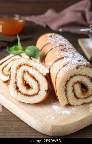 Leckere Kuchenrolle mit Marmelade auf einem Holztisch Stockfoto