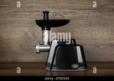 Moderne elektrische Fleischmühle auf Holztisch Stockfoto