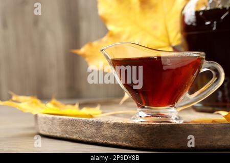 Saucen und eine Flasche leckeren Ahornsirup auf einem Holztisch, Nahaufnahme. Platz für Text Stockfoto
