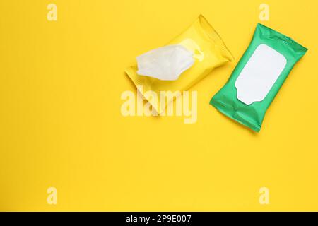 Feuchttücher, Fließpackungen auf gelbem Hintergrund, flach liegend. Platz für Text Stockfoto