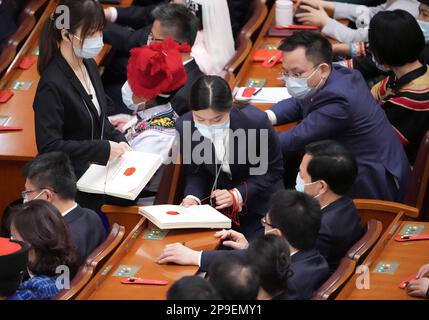 Peking, China. 11. März 2023. Mitarbeiter verteilen die Stimmzettel auf der vierten Plenarsitzung der ersten Sitzung des 14. Nationalen Volkskongresses (NPC) in der Großen Volkshalle in Peking, Hauptstadt von China, am 11. März 2023. Kredit: Xing Guangli/Xinhua/Alamy Live News Stockfoto