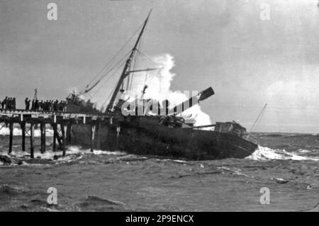 Die Wellen brechen die Gerda auf, die in schwerer See auf das nördliche Wellenbrecherwasser gespült wurde, und zerstörten 11 Buchten des Wellenbrechers, während sie am 23,6.1888 in Greymouth, Westland, Neuseeland eintrafen, und wurden zum totalen Wrack. Alle Besatzungsmitglieder flohen aus dem Eisendampferschiff, das 537 Tonnen brutto wog und ein Nettoregister von 340 Tonnen hatte. Stockfoto