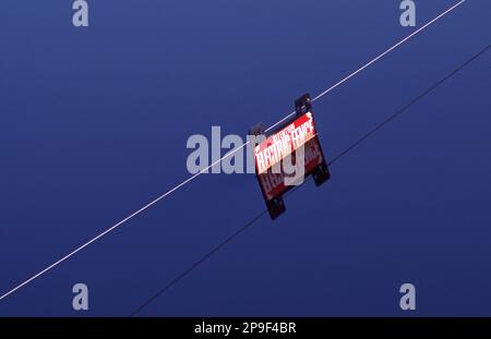 ELEKTRISCHER LEBENDIGER Zaun knapp über dem Wasserstand mit halb versenkem Warnschild nach Überschwemmung auf einem Grundstück im ländlichen New South Wales, Australien. Stockfoto