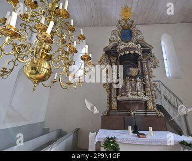 Lunow, Deutschland. 06. März 2023. Ein goldener Kronleuchter schmückt die Kirche mit dem Altar. Pastor Thomas Berg überlässt es nicht dem Zufall, Neuankömmlinge für Lunow zu finden. Es wurde ein professionelles Filmporträt geschaffen, das anschaulich zeigt, was das Dorf an der Grenze zwischen Barnim und Uckermark zu bieten hat. Und das scheint ziemlich viel zu sein. Kredit: Patrick Pleul/dpa/Alamy Live News Stockfoto