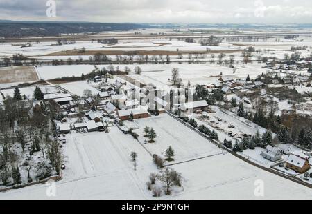 Lunow, Deutschland. 06. März 2023. Mit Schnee bedeckt ist die Landschaft und das Dorf Lunow (Luftaufnahme mit einer Drohne). Pastor Thomas Berg überlässt es nicht dem Zufall, Neuankömmlinge für Lunow zu finden. Es wurde ein professionelles Filmporträt geschaffen, das anschaulich zeigt, was das Dorf an der Grenze zwischen Barnim und Uckermark zu bieten hat. Und das scheint ziemlich viel zu sein. Kredit: Patrick Pleul/dpa/Alamy Live News Stockfoto