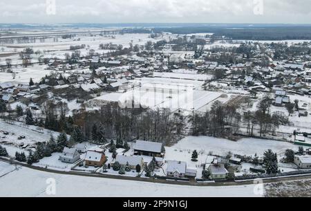 Lunow, Deutschland. 06. März 2023. Mit Schnee bedeckt ist die Landschaft und das Dorf Lunow (Luftaufnahme mit einer Drohne). Pastor Thomas Berg überlässt es nicht dem Zufall, Neuankömmlinge für Lunow zu finden. Es wurde ein professionelles Filmporträt geschaffen, das anschaulich zeigt, was das Dorf an der Grenze zwischen Barnim und Uckermark zu bieten hat. Und das scheint ziemlich viel zu sein. Kredit: Patrick Pleul/dpa/Alamy Live News Stockfoto