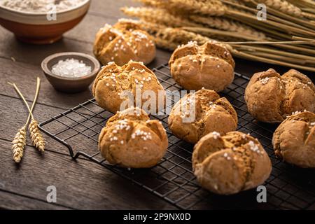 Hausgemachte Spelzbrötchen mit Salz auf Holzhintergrund Stockfoto