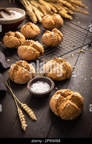 Hausgemachte Spelzbrötchen mit Salz auf Holzhintergrund Stockfoto