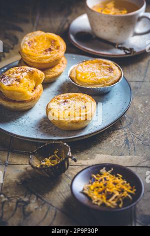 Pastel de nata mit einer Tasse Kräutertee, portugiesischem Süßei und Pudding-Gebäck Stockfoto