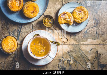 Pastel de nata mit einer Tasse Kräutertee, portugiesischem Süßei und Pudding-Gebäck Stockfoto