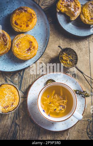 Pastel de nata mit einer Tasse Kräutertee, portugiesischem Süßei und Pudding-Gebäck Stockfoto