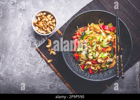 Gebratene Nudeln mit Hühnchen, Gemüse und gerösteten Cashewnüssen umrühren Stockfoto