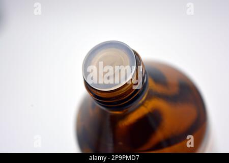 Eine medizinische kleine Flasche Medizin mit einer Flüssigkeit aus schwarzem, braunem Glas auf weißem Hintergrund. Stockfoto