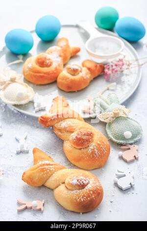 Osterbacken - Brötchen aus Hefeteig in Form von Osterhasen und farbigen Eiern Stockfoto