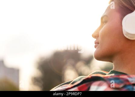 Junge Stadtfrau mit kurzen Haaren in Großkopfhörerporträt. Stockfoto