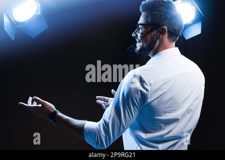 Motivationslautsprecher mit Headset, das auf der Bühne läuft Stockfoto