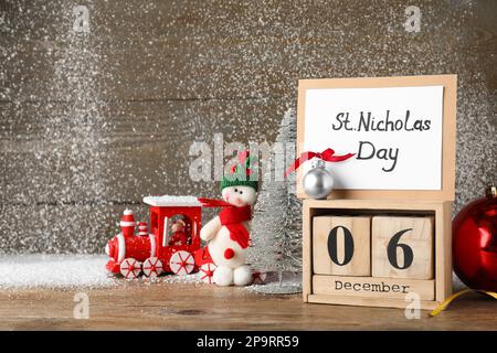 Nikolaustag. Blockkalender mit Datum Dezember 06, Karte und festliches Dekor auf Holztisch Stockfoto