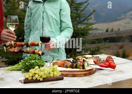 Freunde, die im Freien eine Barbecue-Party feiern, konzentrieren sich auf köstliche Speisen am Tisch Stockfoto