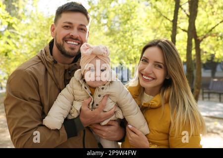 Glückliche Eltern mit ihrem Baby im Park an sonnigen Tagen Stockfoto