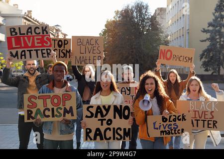 Demonstranten, die im Freien verschiedene Anti-Rassismus-Slogans demonstrieren. Personen, die Schilder mit Phrasen halten Stockfoto